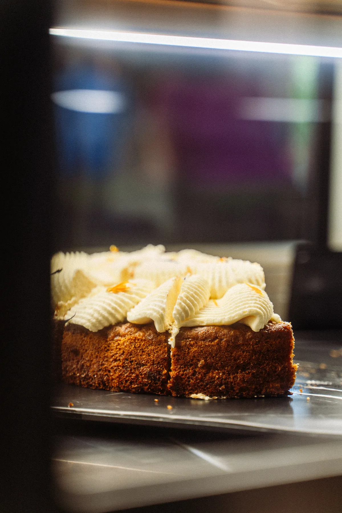 Kuchenstücke mit heller Cremehaube in der Kuchentheke des Waldcafés Blattwerk