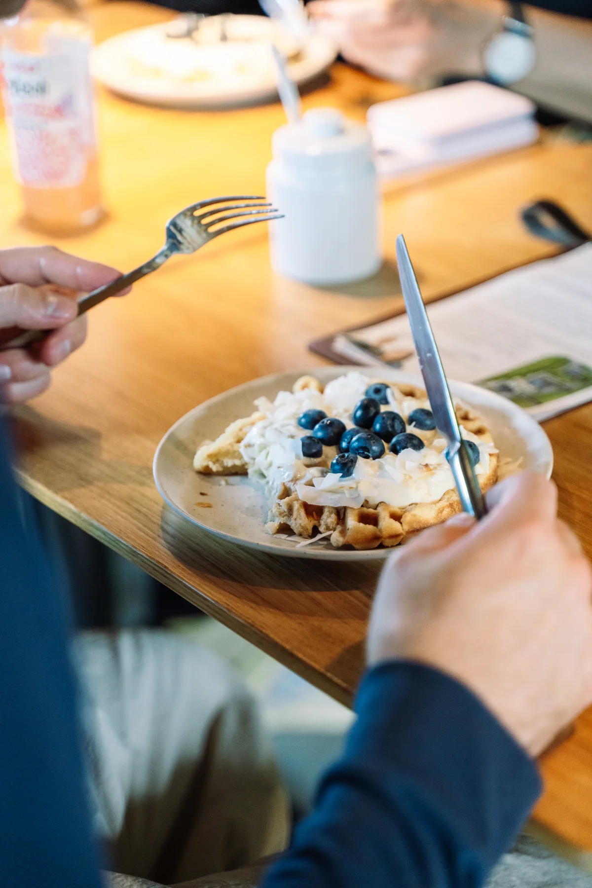 Eine Waffel mit Blaubeeren und Kokosflocken beim gemeinsamen Essen im Café Blattwerk